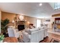 Cozy living room with a stone fireplace, comfortable seating, and an open layout that flows into the dining area at 11605 E Cornell Cir, Aurora, CO 80014
