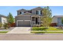 Two-story house with gray siding, attached garage, and manicured lawn at 6112 Black Mesa Rd, Frederick, CO 80516