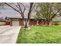 Inviting brick home showcasing a well-maintained lawn, mature trees, and an attached garage with space for two cars at 6365 S Valleyview St, Littleton, CO 80120