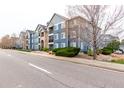 Modern blue apartment complex with well-maintained landscaping, sidewalks, and visible street parking. Unit number five is marked at 4451 S Ammons St # 5-307, Littleton, CO 80123