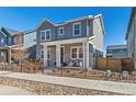 A beautiful gray two-story home features a cozy front porch and well-maintained landscaping at 9080 W 100Th Way, Broomfield, CO 80021