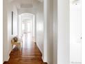 Bright hallway features hardwood floors, white walls, arched doorways, and bench seating at 19473 W 58Th Pl, Golden, CO 80403