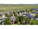 An aerial shot shows well-maintained homes in a peaceful neighborhood, backing onto green fields at 9569 Elk Mountain Cir, Littleton, CO 80125