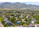 Expansive aerial view showcasing a neighborhood, nearby pond, and rolling mountain landscape at 9569 Elk Mountain Cir, Littleton, CO 80125