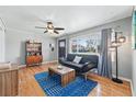Bright living room with hardwood floors, a ceiling fan, and a large window providing ample natural light at 1390 S Glencoe St, Denver, CO 80222