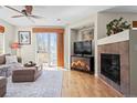 Cozy living room with a fireplace, hardwood floors, and sliding glass doors leading to the outdoors at 17808 E 104Th Pl # C, Commerce City, CO 80022