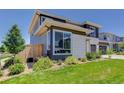 Well-maintained yard with lush green grass and manicured landscaping around the modern gray home at 14290 Hop Clover St, Parker, CO 80134