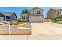 Beautiful two-story home boasts a manicured lawn, white picket fence, and spacious driveway at 606 Beth Ave, Fort Lupton, CO 80621