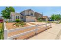 Inviting two-story home with a manicured yard, white fence, and spacious driveway at 606 Beth Ave, Fort Lupton, CO 80621