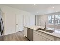 Modern kitchen featuring an island with a sink and stainless steel appliances at 14587 W 90Th Ln # B, Arvada, CO 80005