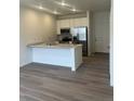 Modern kitchen features stainless appliances, white cabinets, and a center island with a breakfast bar at 14587 W 90Th Ln # B, Arvada, CO 80005