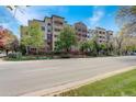 Exterior view of the apartment building with balconies and mature trees along the street at 2200 S University Blvd # 313, Denver, CO 80210