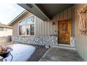 Inviting front entrance with a custom wood door and stone accents at 6066 S Monaco Way, Centennial, CO 80111