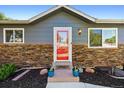 Close-up of home showcasing a striking front door, stone accents, and fresh landscaping that enhances curb appeal at 6074 S Dudley Way, Littleton, CO 80123