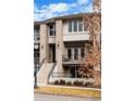 A close up exterior of the townhouse featuring a gray roof, brick facade, and balcony with seating at 32 Jackson St, Denver, CO 80206