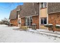 Exterior entrance featuring stone and siding design, plus a snow-covered walkway at 9650 Huron St # 22, Thornton, CO 80260
