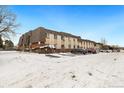 Exterior view of multi-unit complex, featuring parking and snow-covered grounds at 9650 Huron St # 22, Thornton, CO 80260