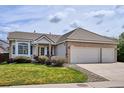 Inviting single-story home featuring a lush green lawn and an attached two-car garage at 10060 Oak Leaf Way, Highlands Ranch, CO 80129