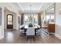 Formal dining room features modern chandelier, neutral colors, and French doors to the backyard at 2260 S Jackson St, Denver, CO 80210