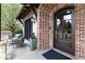 Charming brick entryway showcasing an arched front door, outdoor seating area, and attractive architectural details at 2260 S Jackson St, Denver, CO 80210