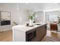 Kitchen island with quartz countertop, modern microwave, and ample sink space with pendant lighting at 1256 Xavier St, Denver, CO 80204
