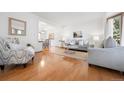 Inviting living room with bright white walls, hardwood flooring, and an open layout to the dining area at 10894 Depew Pl, Westminster, CO 80020