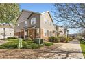 Charming multi-level townhome featuring a stone facade, complemented by lush landscaping and a sidewalk at 12766 Jasmine St # F, Thornton, CO 80602
