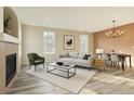 A stylish living room with modern decor, including a fireplace, light grey sofa, and a dining area at 12766 Jasmine St # F, Thornton, CO 80602