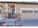Close-up of a home's stone-accented front entry and garage, featuring a charming porch and well-maintained facade at 2976 Open Sky Way, Castle Rock, CO 80109