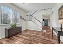 Bright living room with hardwood floors, staircase, and a large window offering ample natural light at 2976 Open Sky Way, Castle Rock, CO 80109
