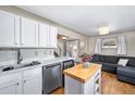 Bright kitchen featuring white cabinets, stainless steel appliances, and an island at 1421 Jasmine St # 1, Denver, CO 80220