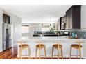 Kitchen with sleek dark cabinets, a breakfast bar, and wood stools at 2931 W 20Th Ave, Denver, CO 80211
