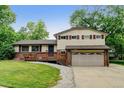 Traditional home with a two-car garage, landscaped front yard, and a welcoming wood deck at 800 Mesa Ct, Broomfield, CO 80020