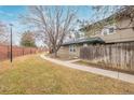 A tranquil backyard features a sidewalk, bordered by a privacy fence and mature trees, offering outdoor enjoyment at 5928 S Willow Way, Greenwood Village, CO 80111