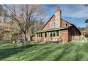 Rustic log cabin with stone chimney, cozy front yard, and inviting curb appeal at 5502 Santa Clara Rd, Indian Hills, CO 80454