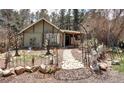 Charming home featuring a brick path and unique garden decor leading to the entrance at 5502 Santa Clara Rd, Indian Hills, CO 80454