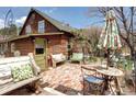 Charming outdoor patio with brick flooring, seating, and lush greenery at 5502 Santa Clara Rd, Indian Hills, CO 80454