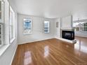 Bright living room featuring hardwood floors and a fireplace at 9437 E 108Th Dr, Commerce City, CO 80640