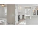 Modern kitchen featuring white cabinets, stainless steel appliances, and light hardwood flooring at 16457 Lafayette St, Thornton, CO 80602