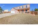 Charming two-story home with a covered porch and two car garage on a sunny day at 2518 S Ouray Way, Aurora, CO 80013