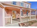 Inviting covered front porch with decorative touches, brick accents, and white railings at 2518 S Ouray Way, Aurora, CO 80013