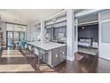 Open concept kitchen with island, breakfast bar and stainless steel appliances and view into bedroom at 3100 Huron St # 2D, Denver, CO 80202