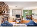 Cozy living room featuring a stone fireplace, hardwood floors, and an open layout at 6251 Willow Ln, Boulder, CO 80301