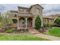Beautiful home with stone accents, a cozy front porch, and a well-maintained lawn with mature landscaping at 9592 Firenze Way, Highlands Ranch, CO 80126