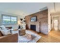 Inviting living room featuring a stone accent wall with a fireplace and hardwood floors at 13211 W 32Nd Ave, Golden, CO 80401