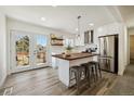 Modern kitchen featuring a kitchen island and French doors leading to a deck at 1549 S Telluride St, Aurora, CO 80017