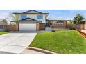 Charming home with a brick and siding exterior, green lawn, and an attached garage with concrete driveway at 13390 W Warren Ave, Lakewood, CO 80228