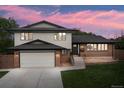 Beautiful home with a well-kept lawn, brick accents, gray siding, and an attached two-car garage at 13390 W Warren Ave, Lakewood, CO 80228
