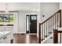 Inviting foyer with hardwood floors, staircase, and a stylish front door with decorative glass accents at 13390 W Warren Ave, Lakewood, CO 80228