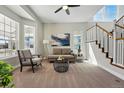 Bright living room with high ceilings, large windows, neutral-toned furniture, and a modern, abstract art piece at 6273 Torrey Ln, Arvada, CO 80403